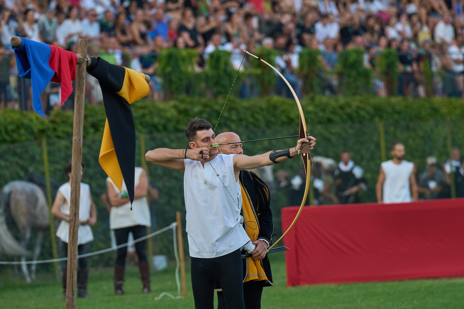 Caccia del Toro: arciere in costume rinascimentale prende la mira con l'arco al bersaglio mobile durante il Palio dei Terzieri.